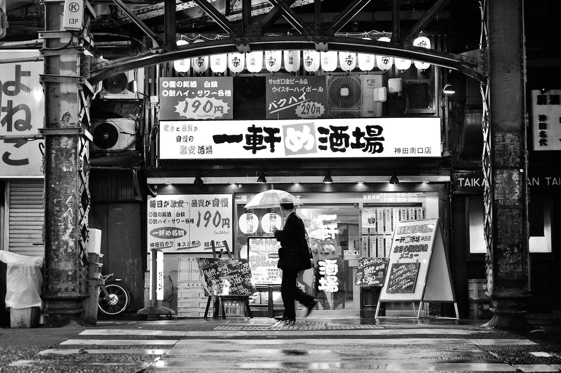 A man walks in the rain near Kanda station’s entertainment area.