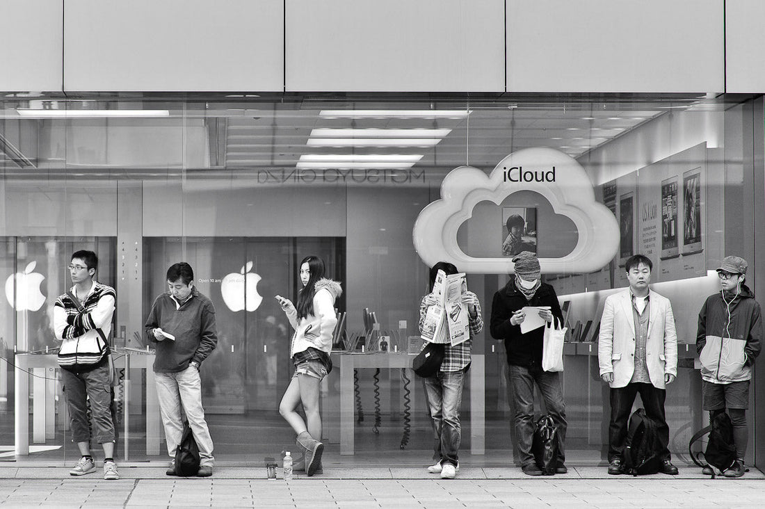 A woman makes eye contact standing line at the Apple Ginza store.