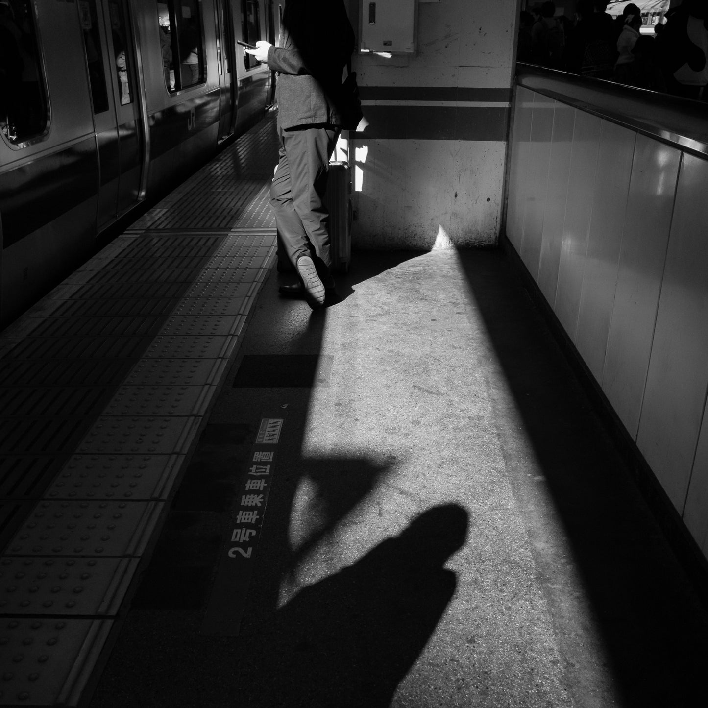 A man waits for a train at Akabane station.