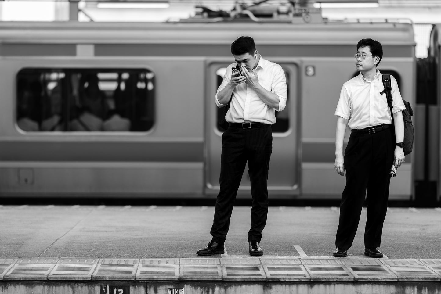 Two men waiting for a train in Akaben, Tokyo.