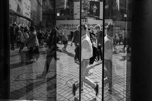 A man and his reflection in a glass phone booth at Shibuya crossing- Tokyo Photo Tour