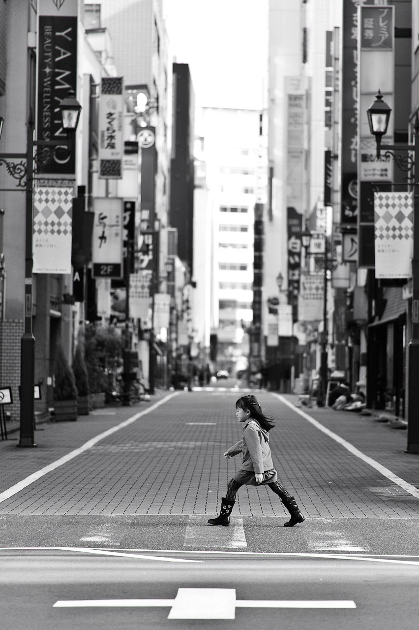 A young girl crosses the street in Ginza.