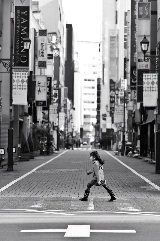 A young female shopper crosse the cobble stone streets of Ginza 