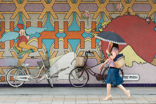 A women walks past an eclectic tapestry in Omiya, Japan