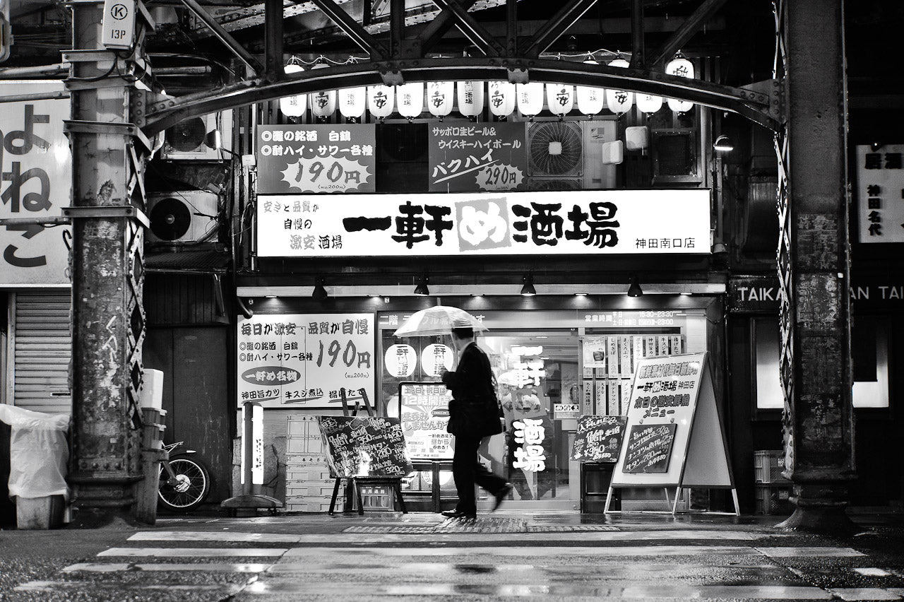 A man walking in the rain past paper lanterns in Kanda, Tokyo 