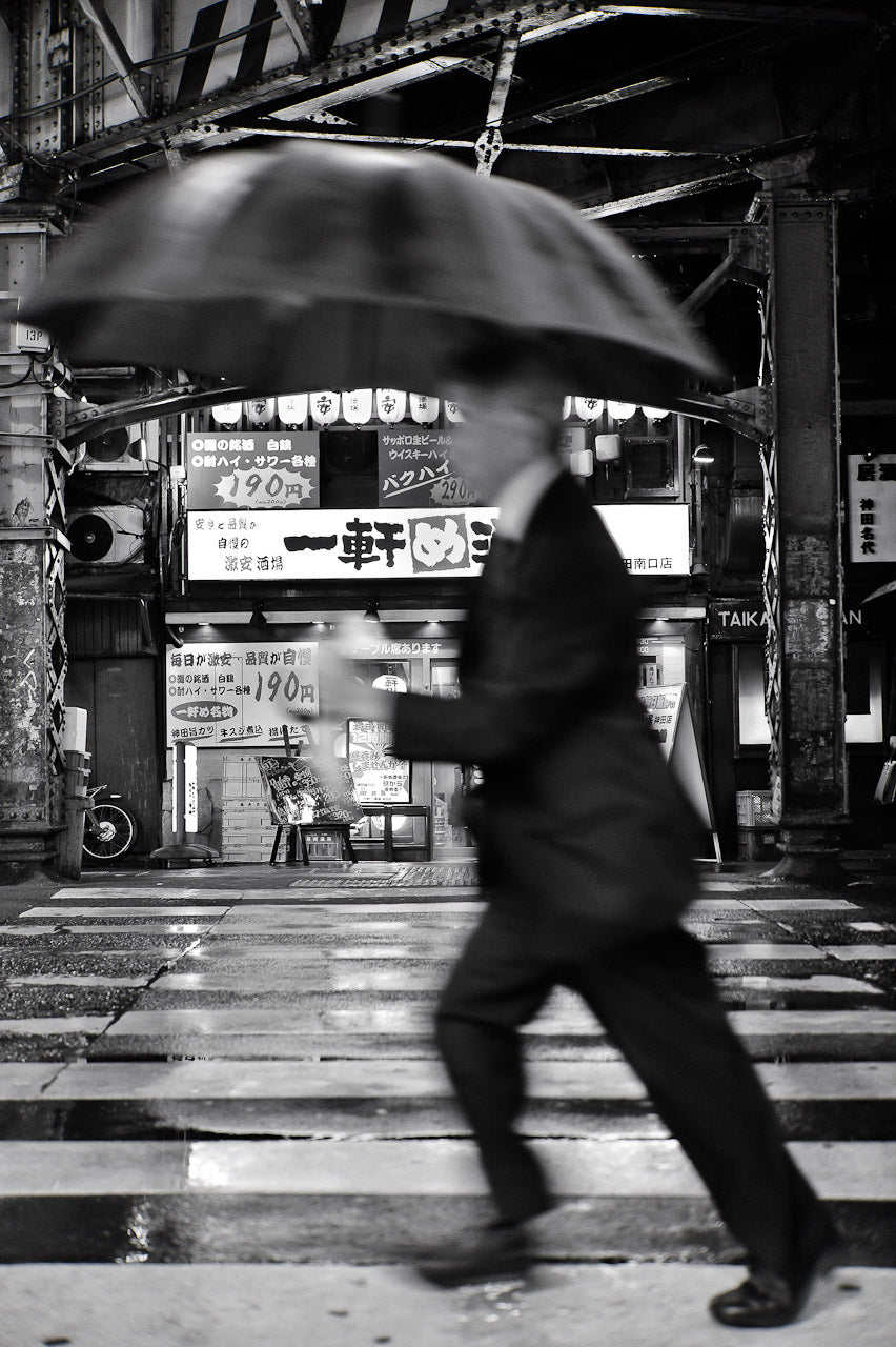 A man walking in Kanda, Tokyo in the rain.